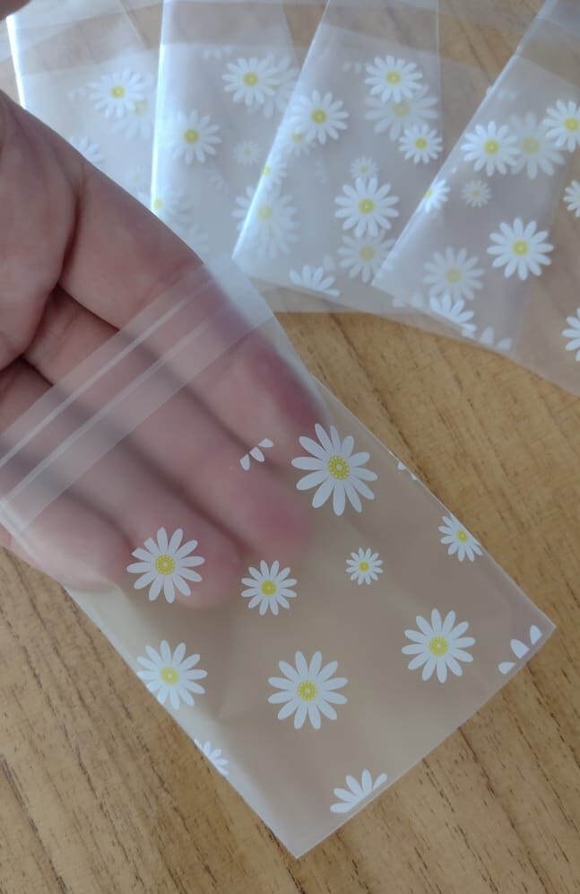 BOLSA ESTAMPADA DE POLIPROPILENO C/ ADHESIVO 7X10. DISEÑO FLORES BLANCAS X25U